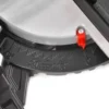 Close-up of a power tool blade guard with a red locking pin attached.