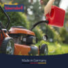 Close-up of an orange lawn mower being fueled with a red gas can in a garden; 'Made in Germany' banner visible.