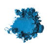 Blue pigment powder scattered in a loose pile on a white background, with darker chunks at the edges