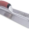 Metal notched trowel with a red handle used for tile setting, resting on a flat steel blade edge section.