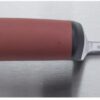 Red-handled utility knife with a metal straightedge ruler extended on both sides, lying on a stainless work surface.